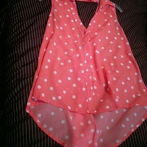 Orange blouse with white polka dots, sleeveless.